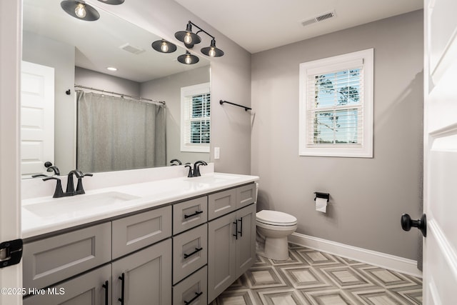 bathroom with walk in shower, vanity, and toilet