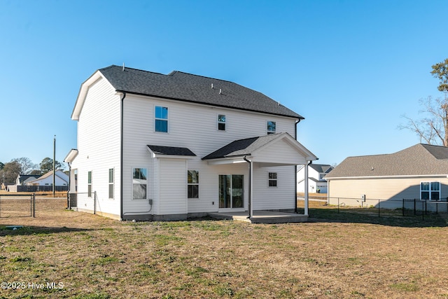 rear view of property with a patio and a lawn