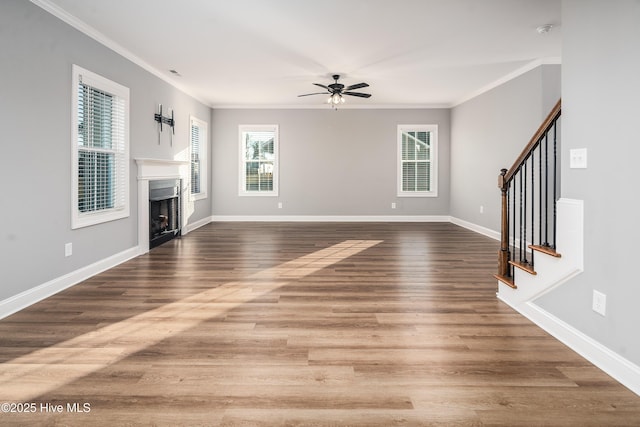 unfurnished living room with ornamental molding, wood-type flooring, and a healthy amount of sunlight