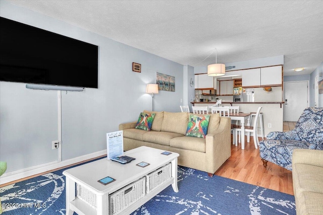 living room featuring light hardwood / wood-style floors and a textured ceiling