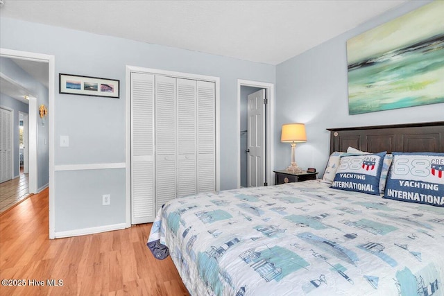 bedroom with light hardwood / wood-style floors and a closet