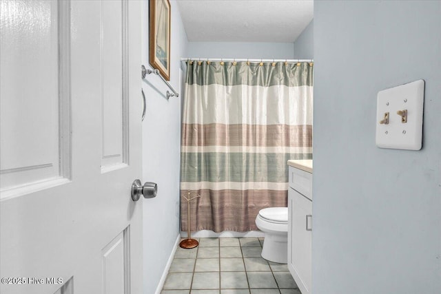 bathroom featuring tile patterned floors, vanity, a textured ceiling, and toilet