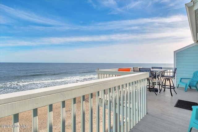 balcony featuring a water view and a view of the beach