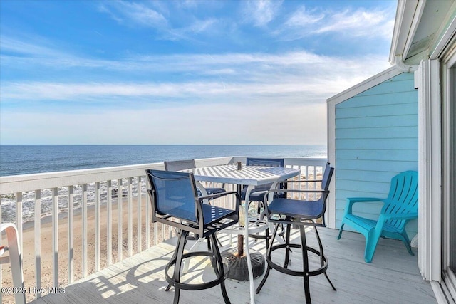 balcony with a water view and a view of the beach