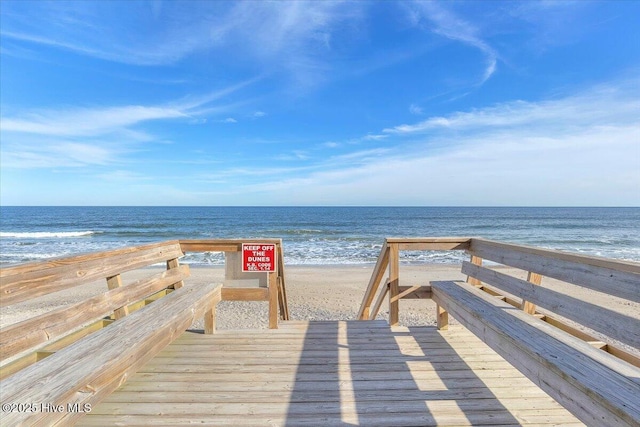 view of property's community with a water view and a beach view