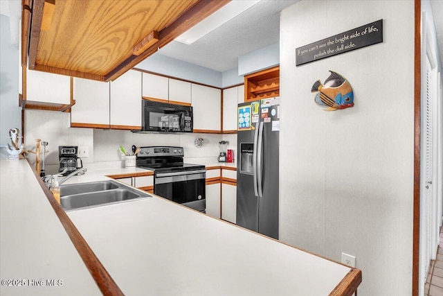 kitchen featuring a textured ceiling, sink, white cabinetry, and stainless steel appliances