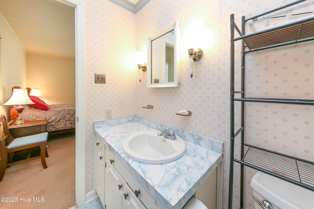 bathroom with toilet, vanity, and ornamental molding