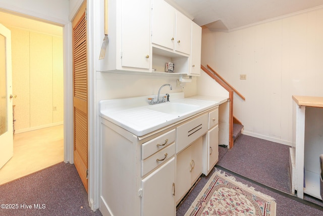 kitchen featuring carpet, white cabinetry, and sink