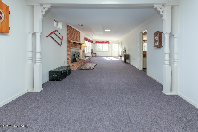 unfurnished living room featuring carpet and a brick fireplace