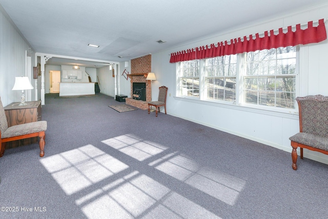 carpeted living room featuring a brick fireplace