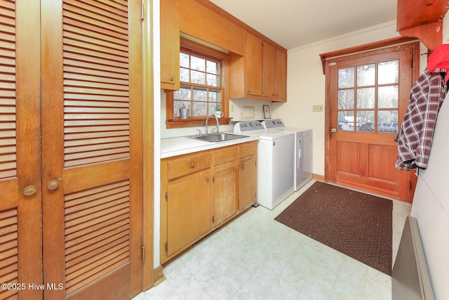 laundry room featuring washer and clothes dryer, crown molding, cabinets, and sink