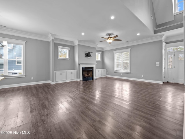 unfurnished living room with dark hardwood / wood-style flooring, ceiling fan with notable chandelier, and ornamental molding