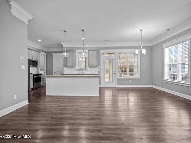 unfurnished living room with dark hardwood / wood-style floors, ornamental molding, sink, and an inviting chandelier