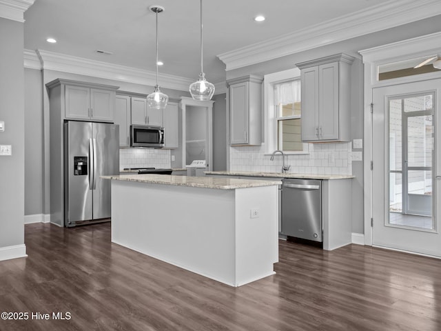 kitchen with gray cabinetry, pendant lighting, a kitchen island, and appliances with stainless steel finishes