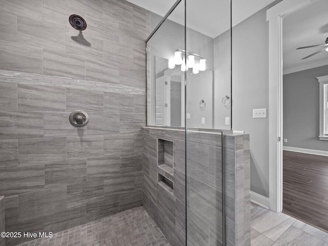 bathroom with crown molding, ceiling fan, and tiled shower