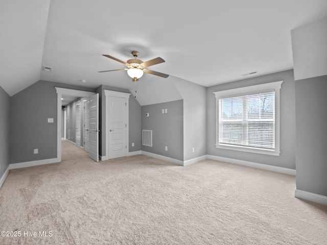 additional living space with light colored carpet, ceiling fan, and lofted ceiling