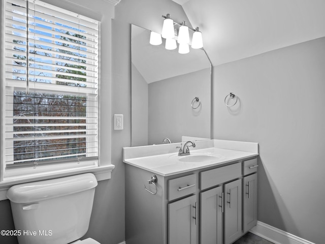 bathroom with vanity, toilet, and vaulted ceiling