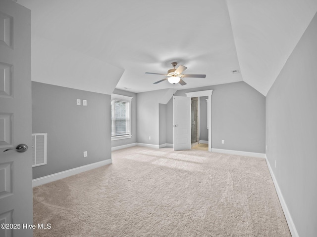 additional living space with ceiling fan, light colored carpet, and lofted ceiling