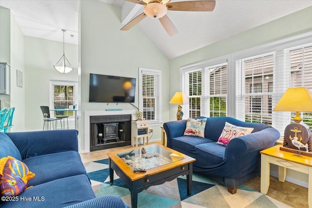 tiled living room with a textured ceiling, ceiling fan, and high vaulted ceiling