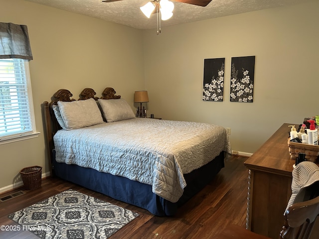 bedroom featuring ceiling fan, dark hardwood / wood-style floors, and a textured ceiling