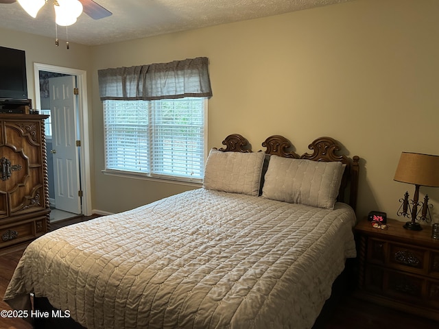 bedroom with a textured ceiling, dark hardwood / wood-style floors, and ceiling fan