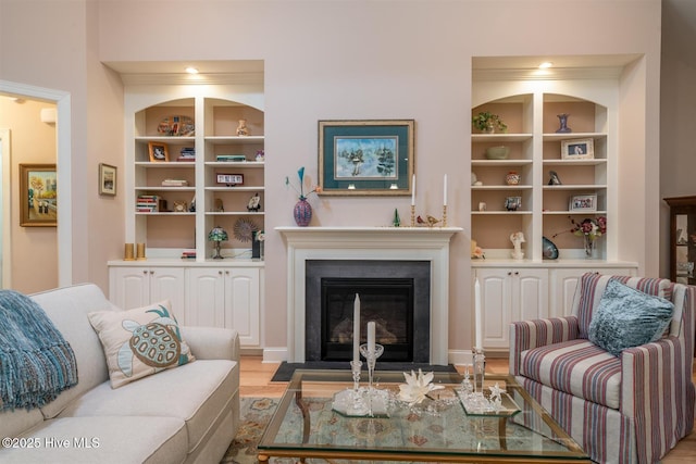 living room featuring built in shelves and light wood-type flooring