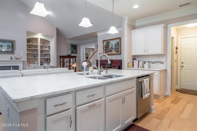 kitchen featuring white cabinets, dishwasher, sink, and an island with sink