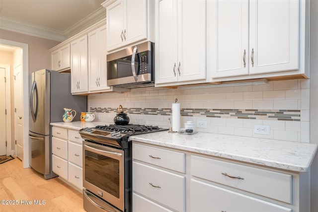 kitchen featuring white cabinets, light stone countertops, ornamental molding, tasteful backsplash, and stainless steel appliances