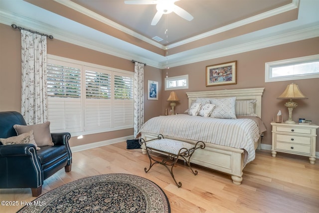 bedroom with a raised ceiling, ceiling fan, crown molding, and light wood-type flooring