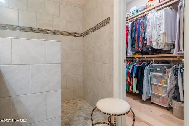 bathroom with hardwood / wood-style floors and a tile shower