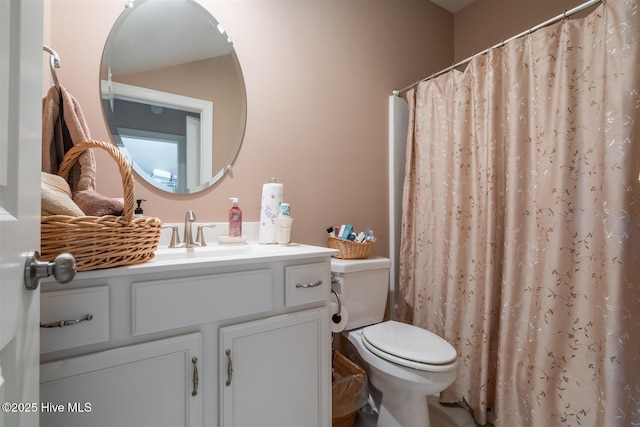 bathroom featuring vanity, toilet, and curtained shower