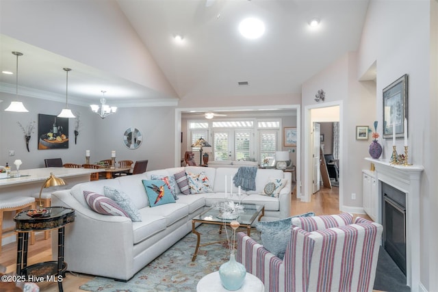 living room with crown molding, high vaulted ceiling, light hardwood / wood-style floors, and ceiling fan with notable chandelier