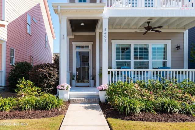 entrance to property with covered porch, ceiling fan, and a balcony