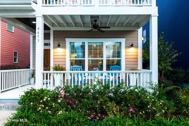 property entrance featuring covered porch, a balcony, and a ceiling fan