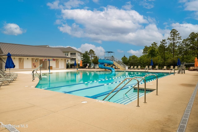 community pool with a patio and a water slide