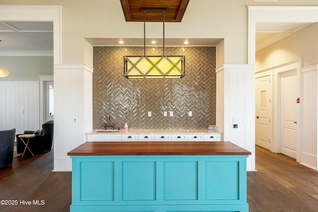 kitchen with dark wood finished floors, butcher block counters, crown molding, and blue cabinetry