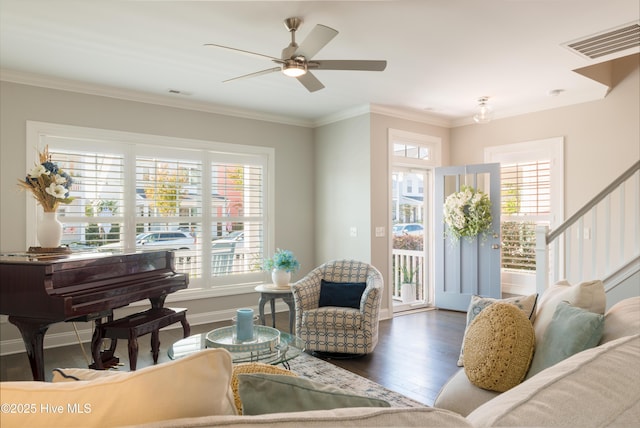 sitting room with a healthy amount of sunlight, visible vents, wood finished floors, and ornamental molding