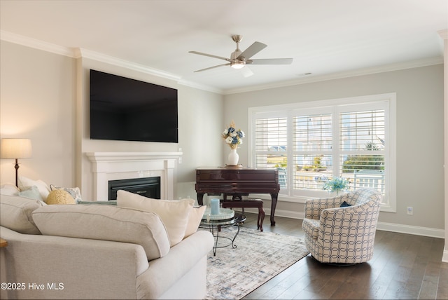 living room with ceiling fan, a fireplace, dark wood-type flooring, and crown molding