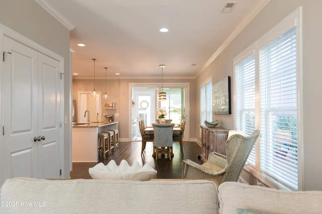 living room with dark wood-style floors, ornamental molding, and recessed lighting