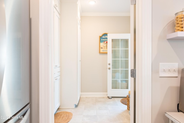 corridor featuring ornamental molding, light tile patterned flooring, and baseboards