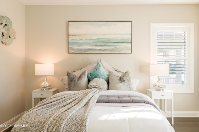 bedroom with baseboards and wood finished floors