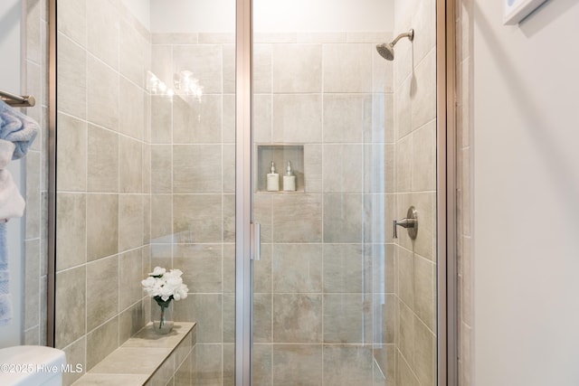 bathroom featuring a stall shower and toilet