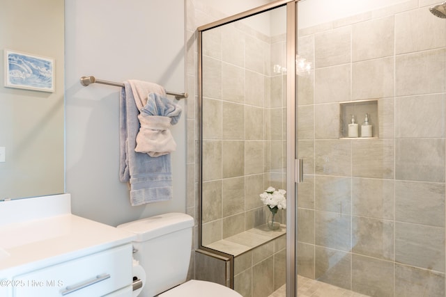 full bathroom with a stall shower, vanity, and toilet