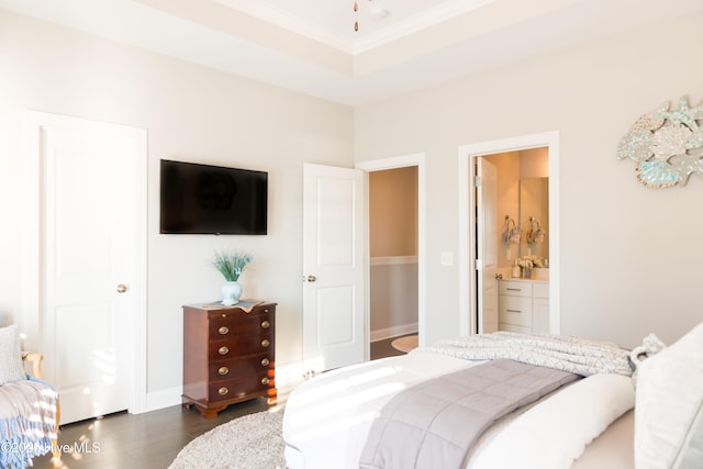 bedroom with dark wood-style floors, baseboards, connected bathroom, and ornamental molding