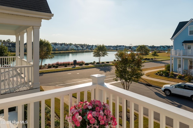 balcony featuring a residential view and a water view