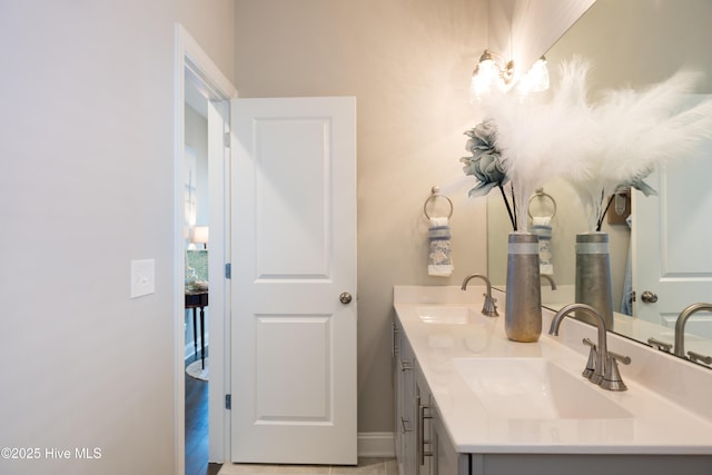 full bath with a sink, baseboards, and double vanity