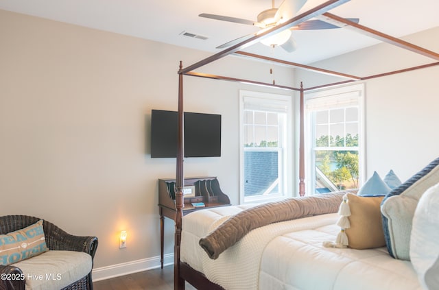 bedroom featuring dark wood-style floors, ceiling fan, visible vents, and baseboards