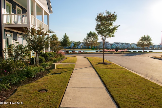 view of street featuring a water view, sidewalks, and a residential view