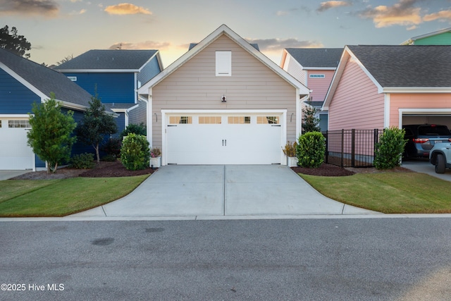 traditional-style home with driveway, an attached garage, and fence