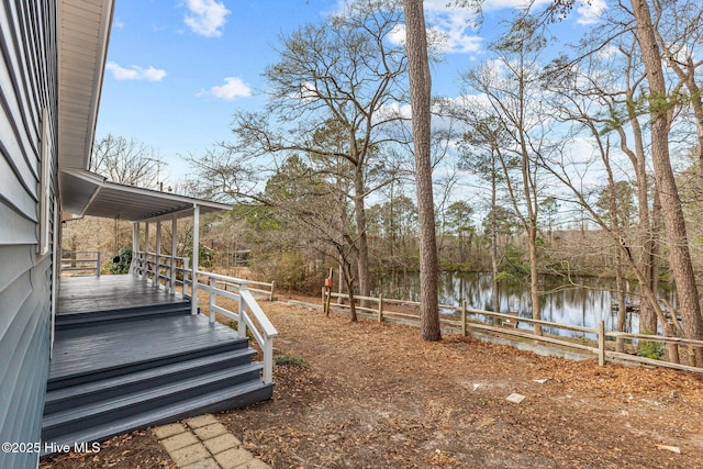 view of yard with a deck with water view